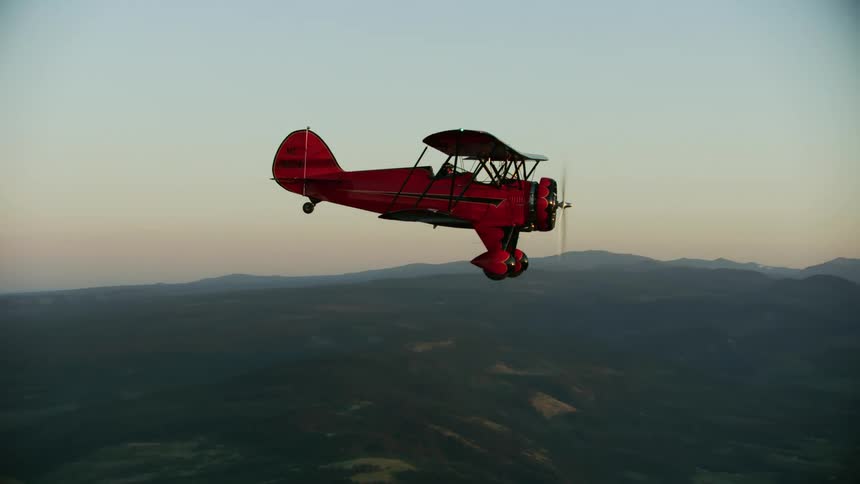 A red WACO biplane flies in front of Mount Hood in Oregon