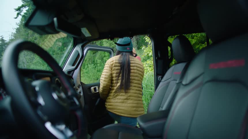 A young woman is getting out of the car and going outside with someone else