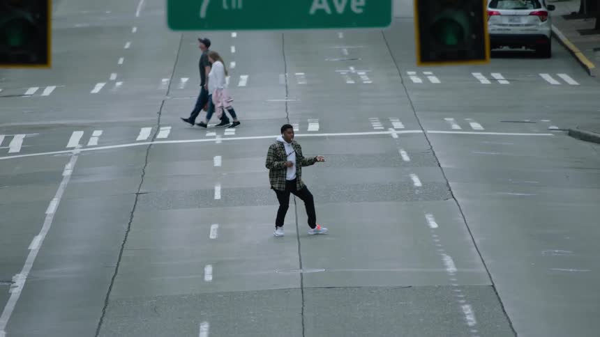 A man dancing and walking down a road