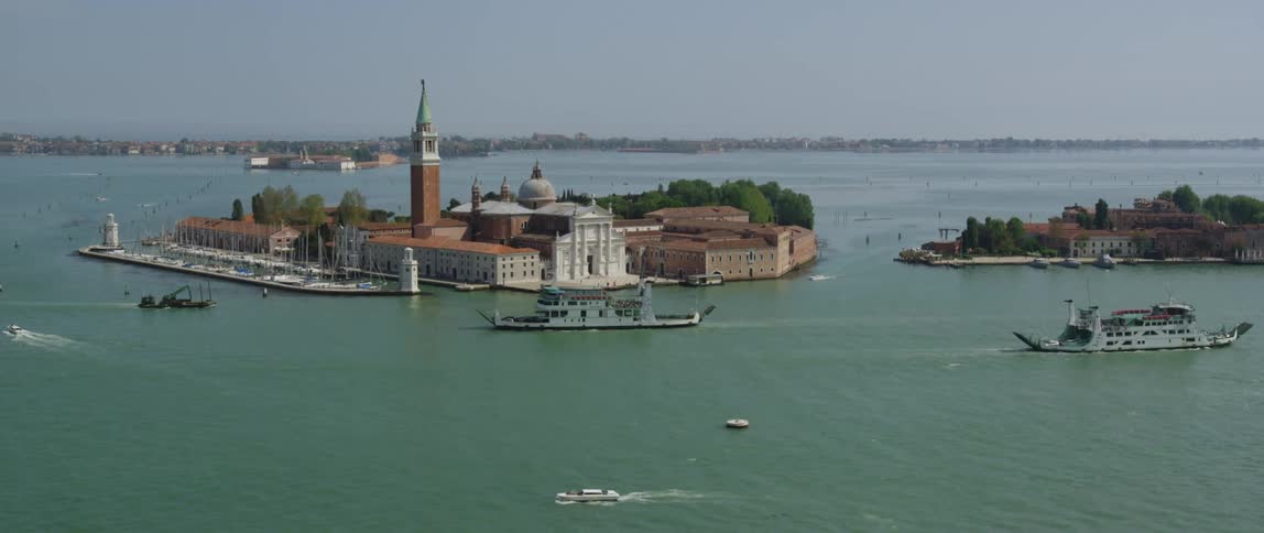 Two ferries and several boats traveling in the canal past san giorgio monastery in venice
