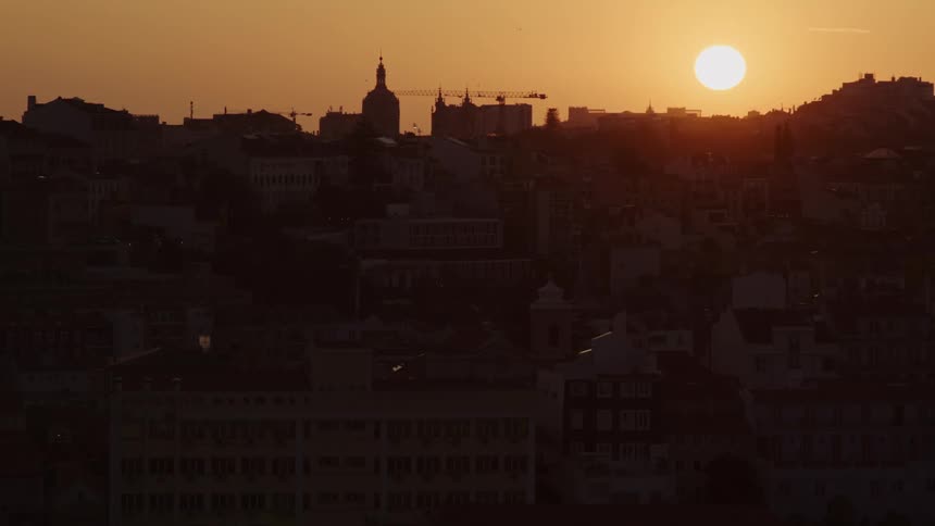 The sun is setting in the horizon of a city skyline