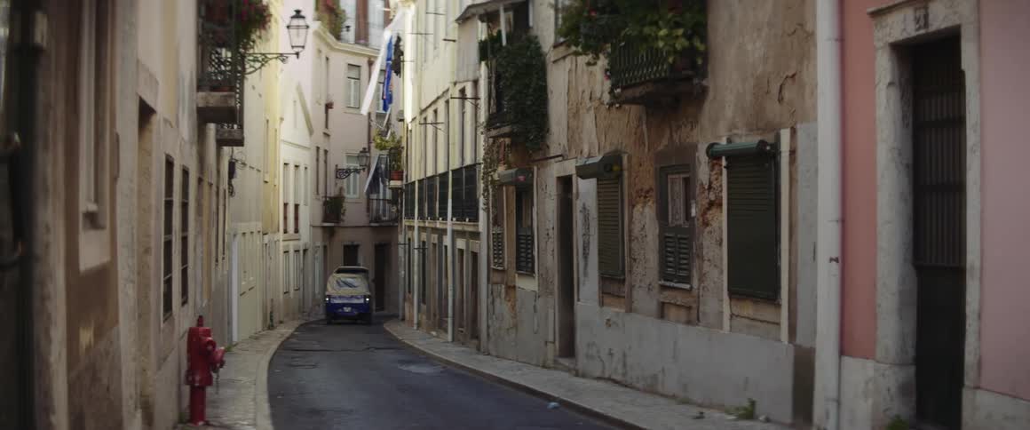A car is driving through a neighborhood during daytime
