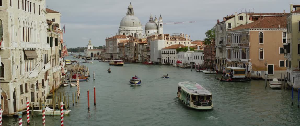 Boats carrying tourists moving on a canal in the city of venice in italy