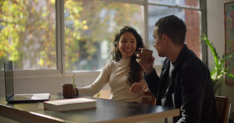Man and woman are having a conversation together while drinking coffee