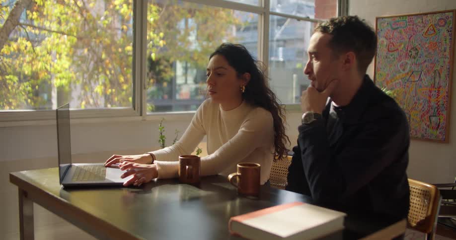 Two friends are hanging out and surfing the web on a laptop