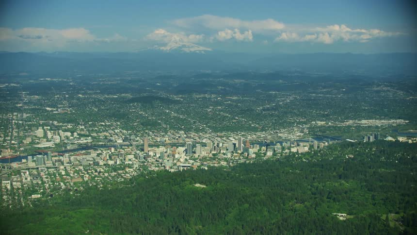 High altitude aerial of downtown Portland Oregon as the camera flies over the west hills looking at downtown and the southeast neighborhoods
