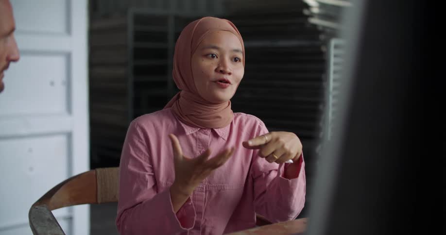 A woman explaining something to a man in a business meeting