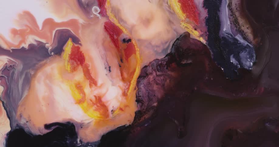 Dark liquid ink blooms mixing with surrounding red and yellow ink in waves