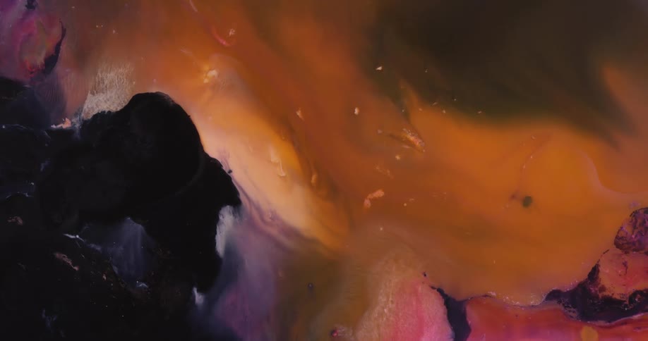Intense dark yellow liquid ink blooms swirling over a black background