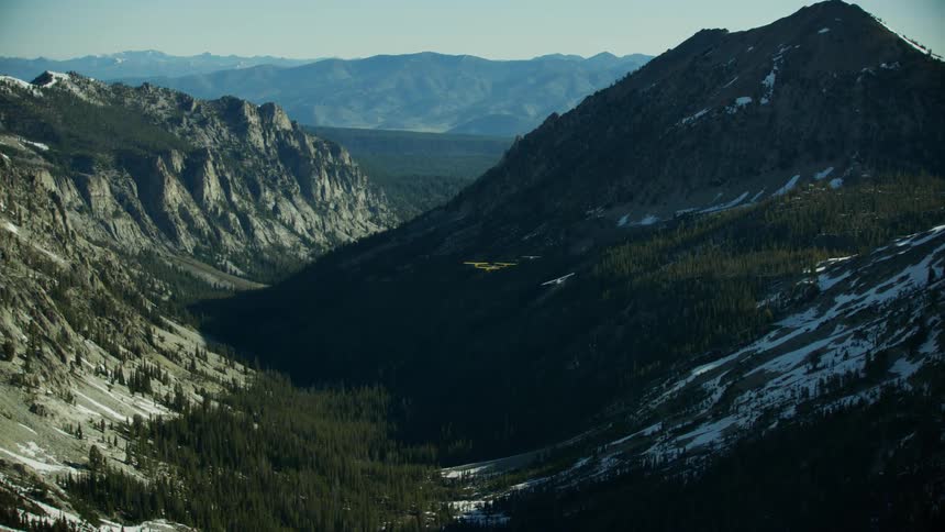 A group of six Backcountry airplanes fly over a wide open mountainous area in the Idaho Backcountry