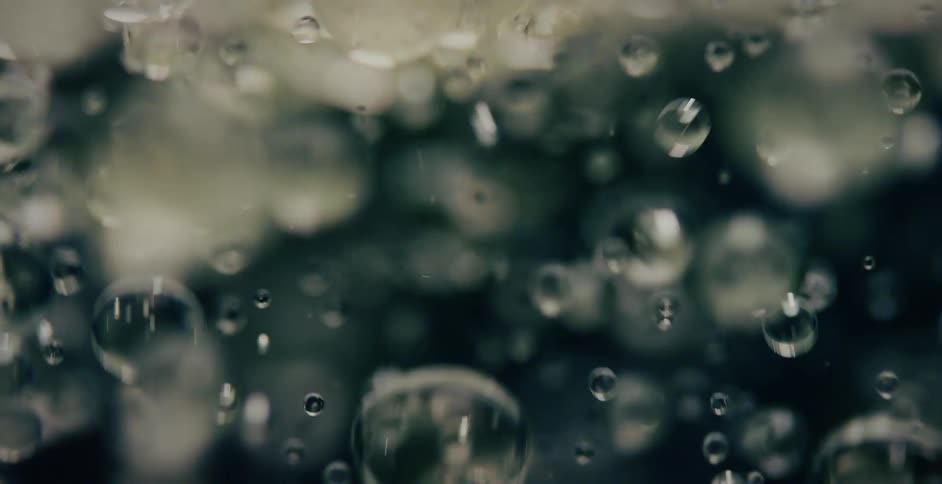 Bubbles are reflecting light as they float upwards in liquid