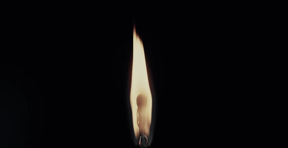 Flame ignites and grows on a burned matchstick