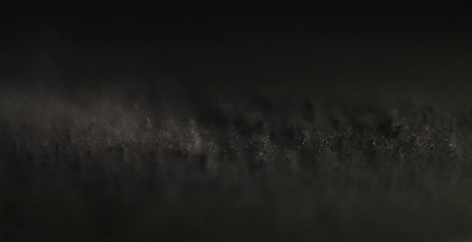 Black particles bounce up and down on a surface