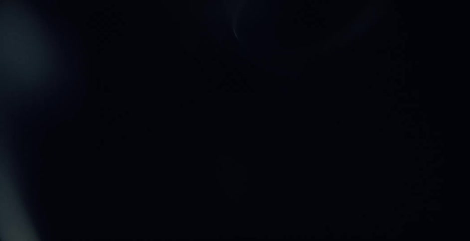 Smoke rises and goes from white to blue in the darkness