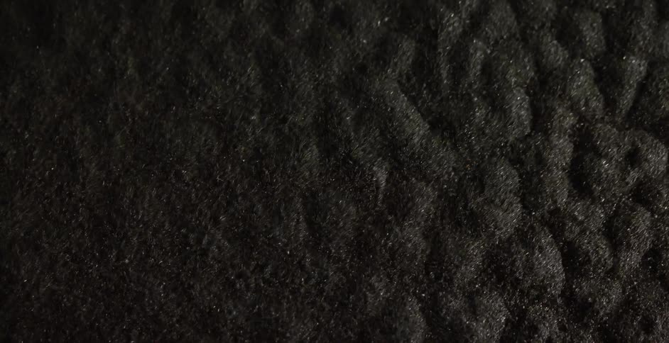 Black particles bounce up and down on a surface