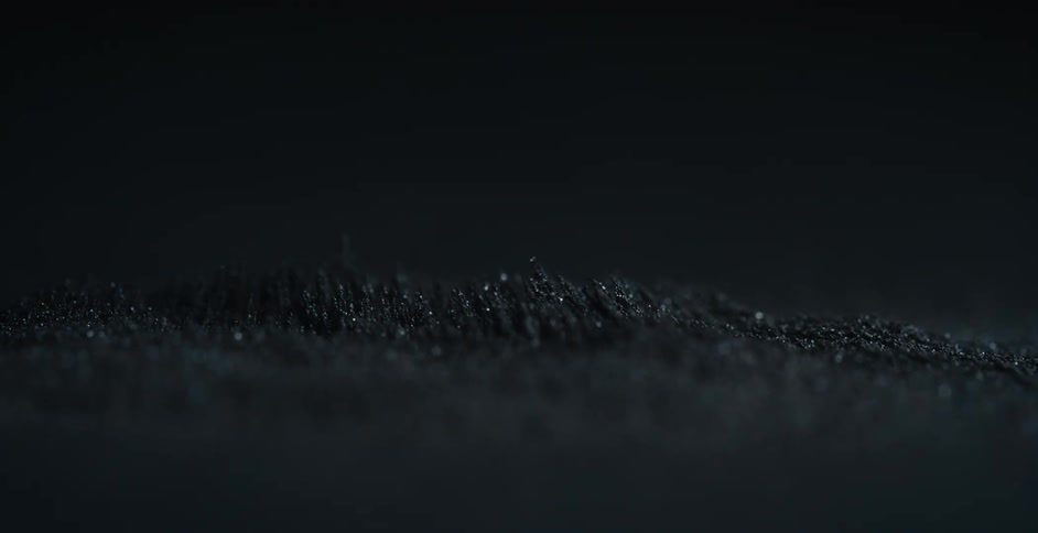 A magnetic force moves particles of sand side to side