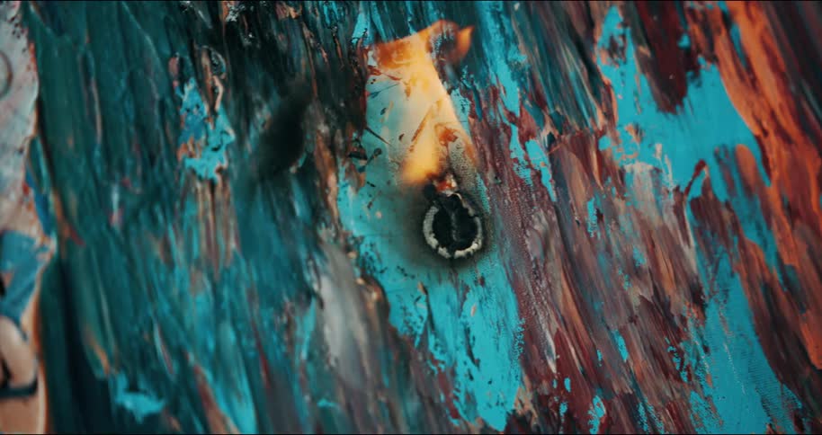 A circular flame is burning on some painted wood