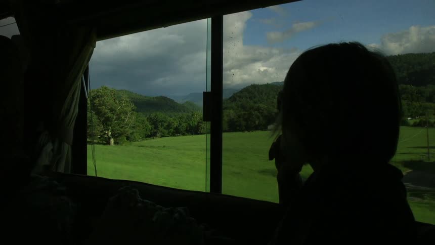 Person rides in an rv and looks out over a rural area