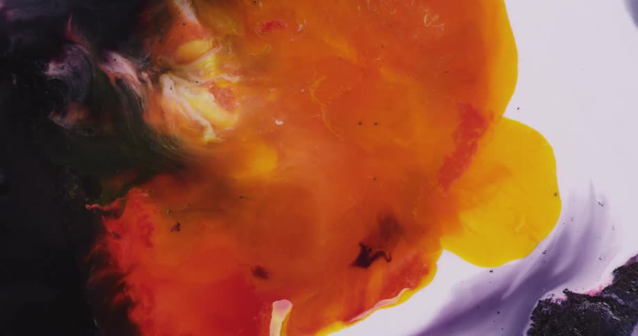 Yellow orange red and purple colors mix together in a liquid like substance