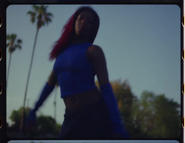 Young woman with red hair dances on a park at morning caught on vintage film