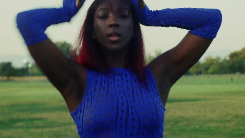 A woman is practicing a dance routine in the park