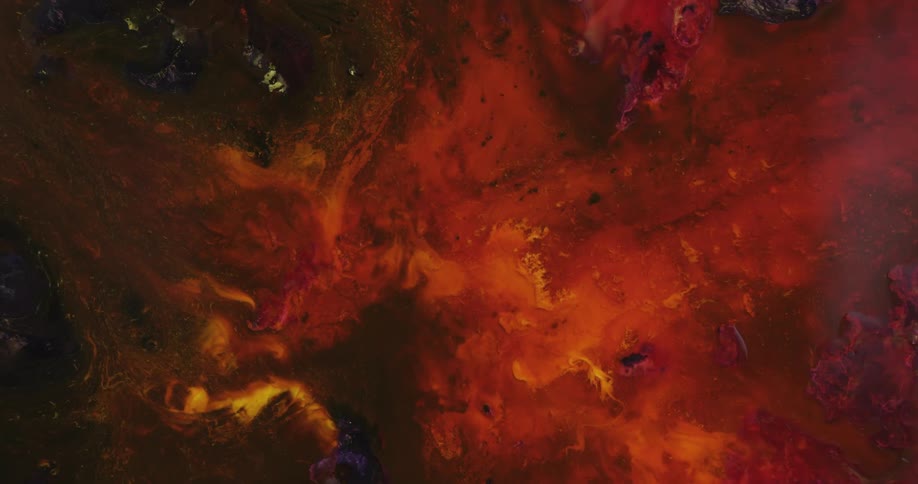 Organic flaming red and orange liquid colors slowly move in the darkness