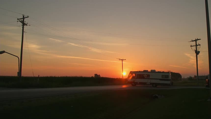 An rv turns and drives away at sunset