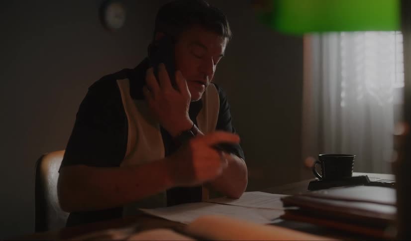 A man takes notes while talking on the phone