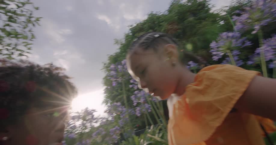 Siblings dance while doing a synchronized clapping game in their garden