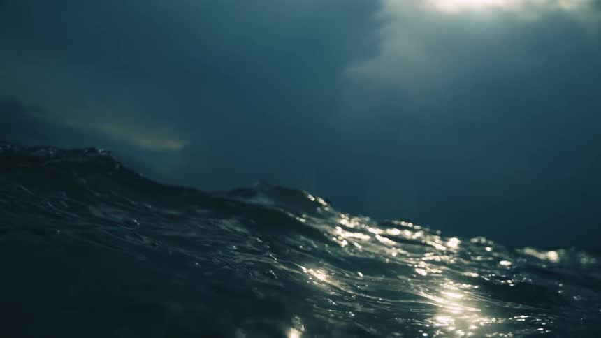 Ocean waves on a stormy day break over the camera