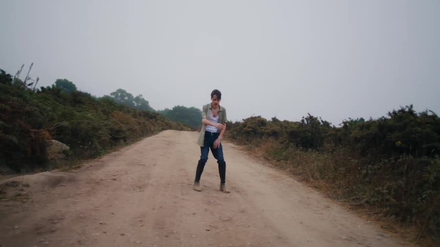 A man paces back and forth in frustration on a dirt road