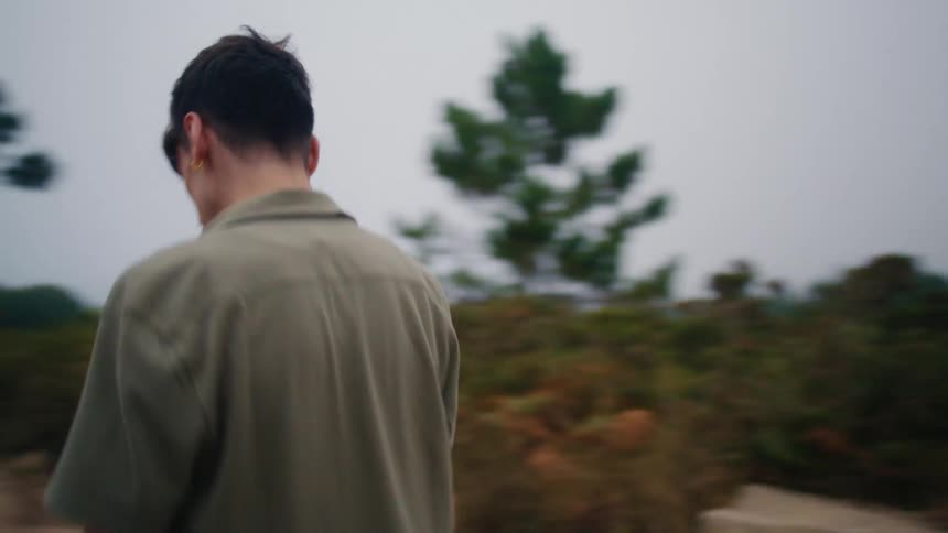 Man walks down dirt road through brush