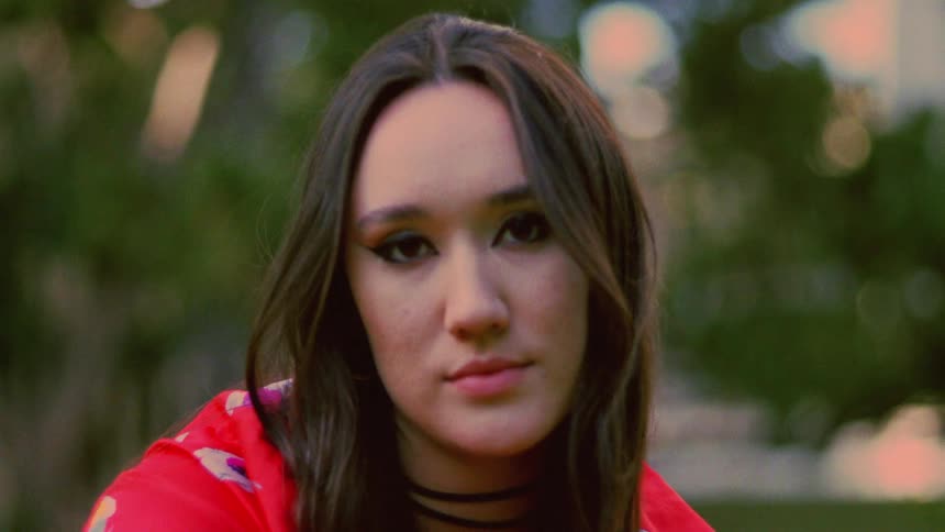 Close up of the face of a young woman wearing a colorful red jacket outdoors