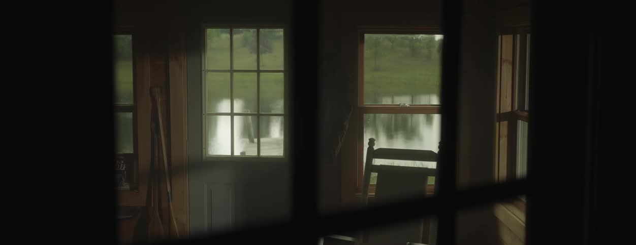 A view of a house by a lake is displayed in spring