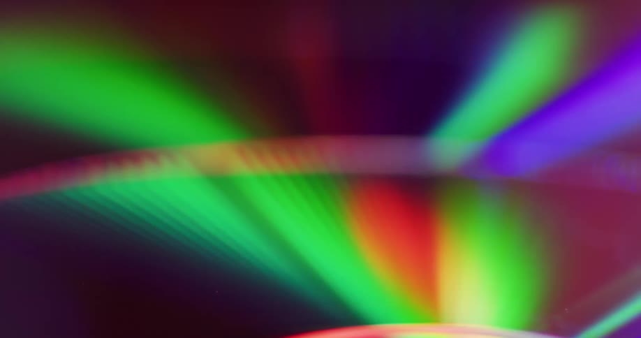 Neon lights reflect off chrome compact discs