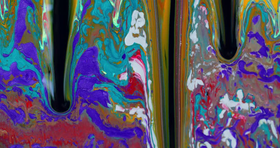Paint slowly drips down as blue red and gold colors combine together