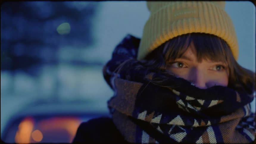 A woman is cold and bundled up outside