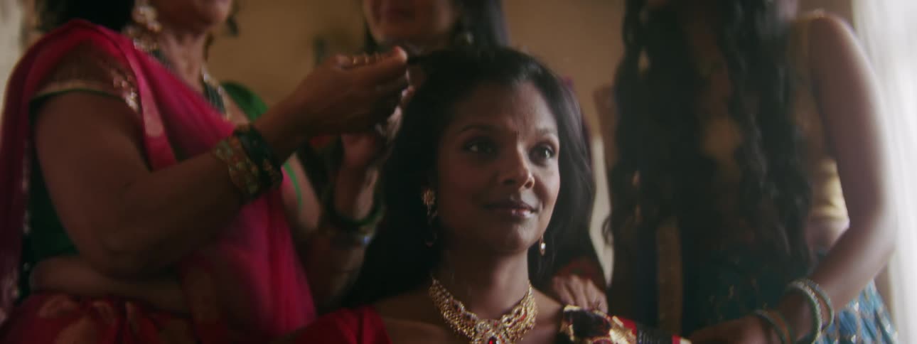 A group of women are styling another womans hair