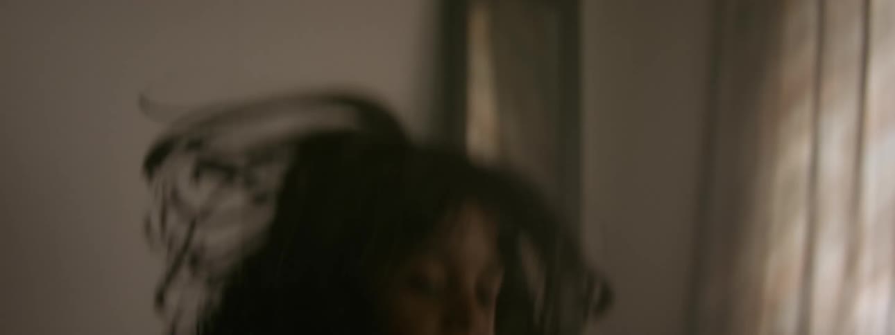 A young girl jumps up and down in a bedroom