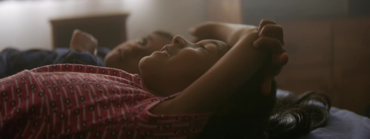 Siblings lie on the floor and look at the ceiling