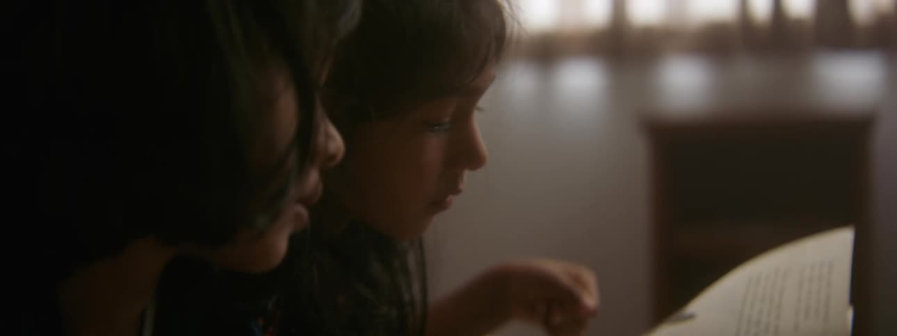 Two children read a book together