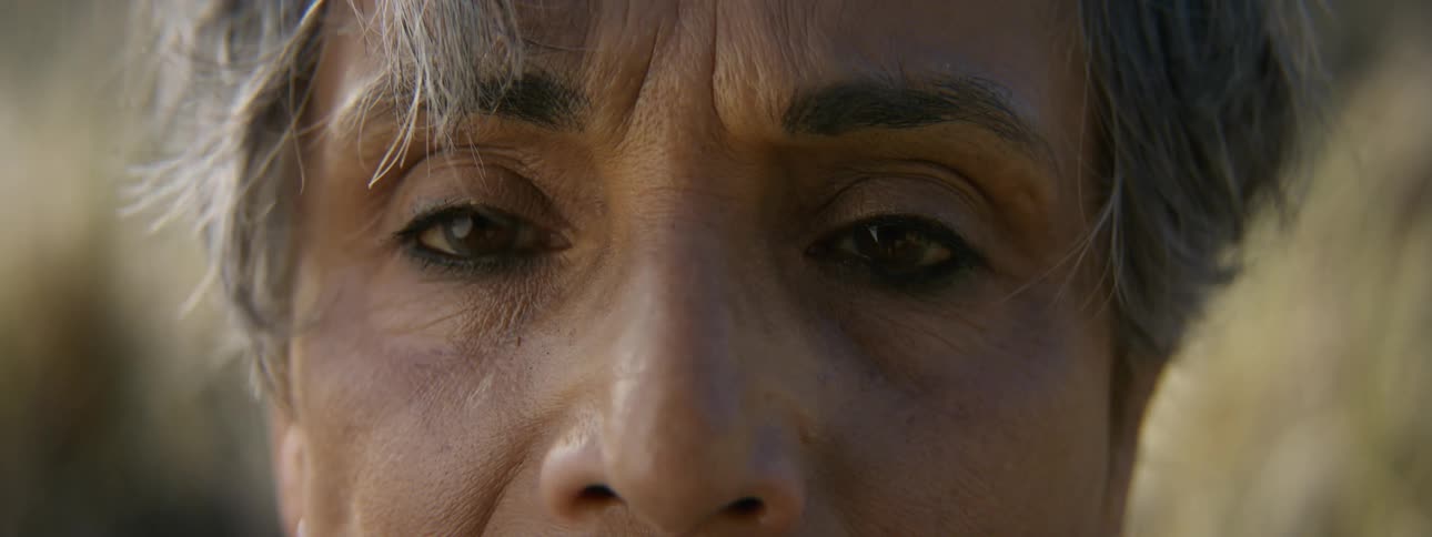 A woman has her eyes closed as her hair moves in the breeze and when she opens them she looks tired