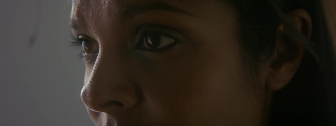 Woman with dark hair stares into space