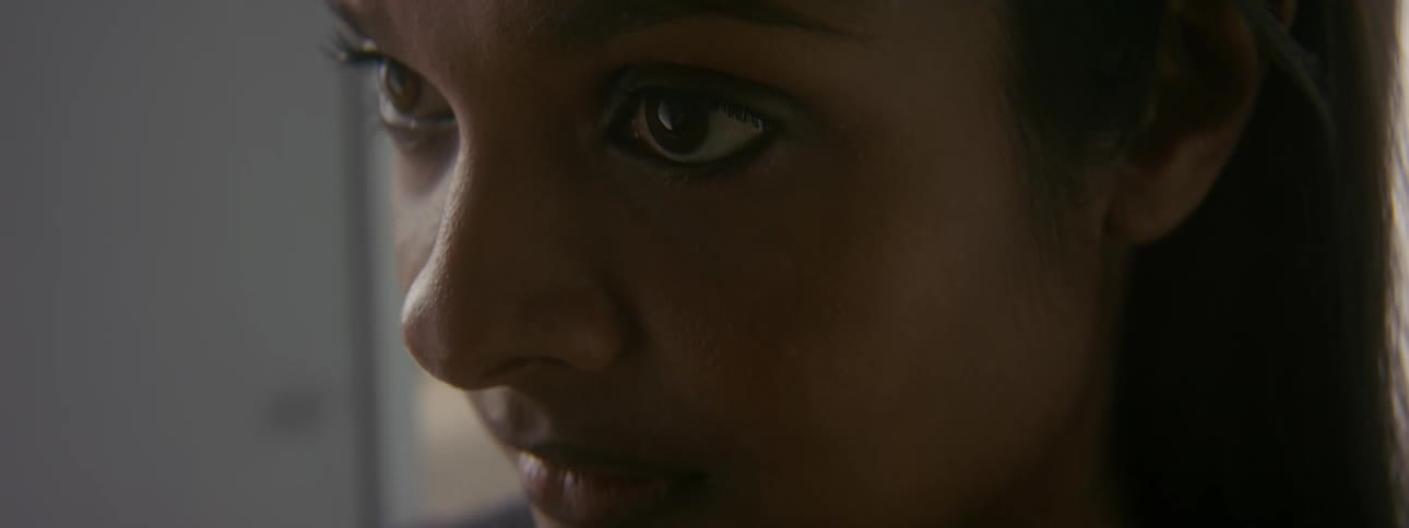Girl with dark hair lifts her head up staring into space
