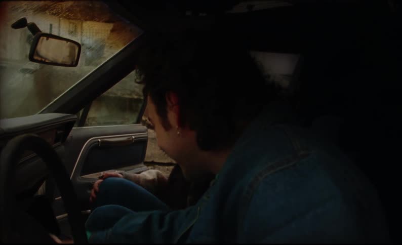 A man and woman get into their car and check their cell phones