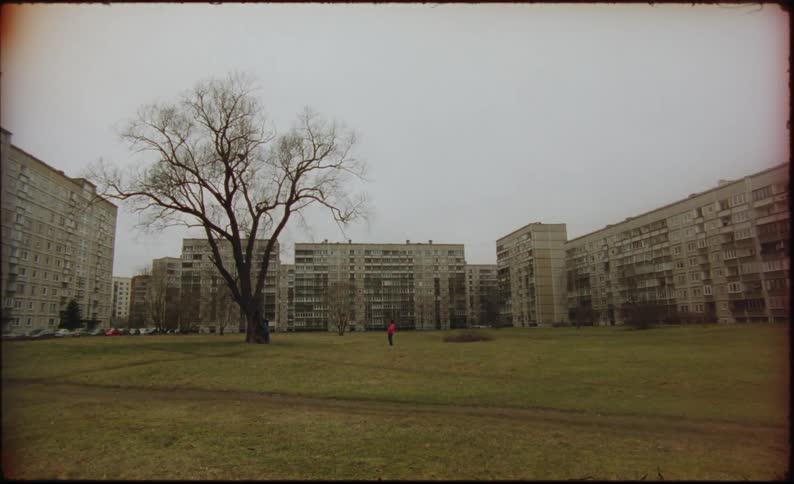 Two humans can be seen off in the distance running on a grassy field