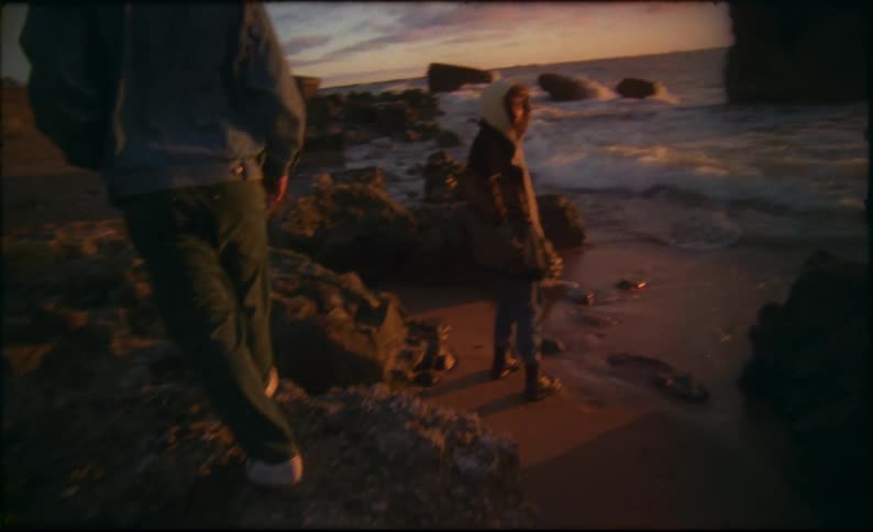 Two people walk on the beach