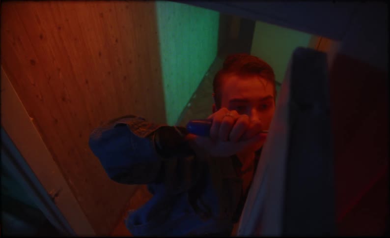 A man attempts using a screwdriver on an object but ends up striking it in frustration