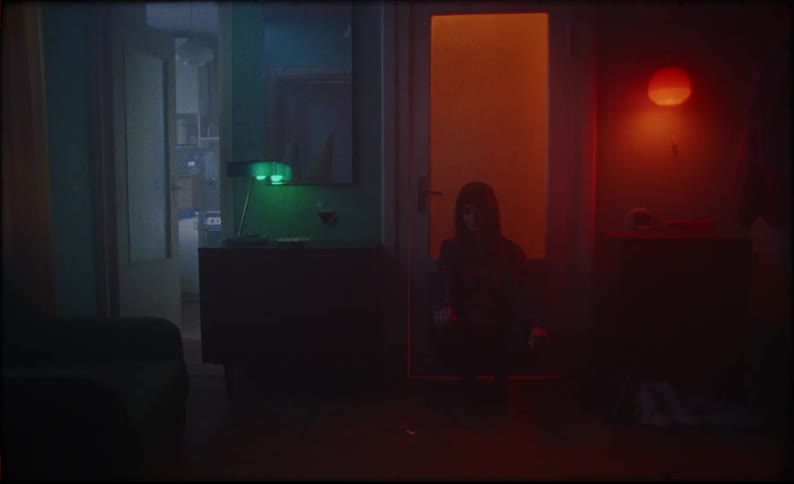 A woman walking into a room and sitting down