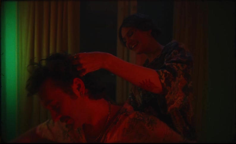 A woman cuts a mans hair then kisses him